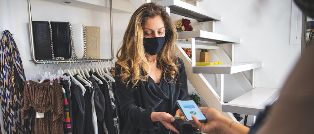 Contactless payment during Covid-19 pandemic using all safety protection with mask.