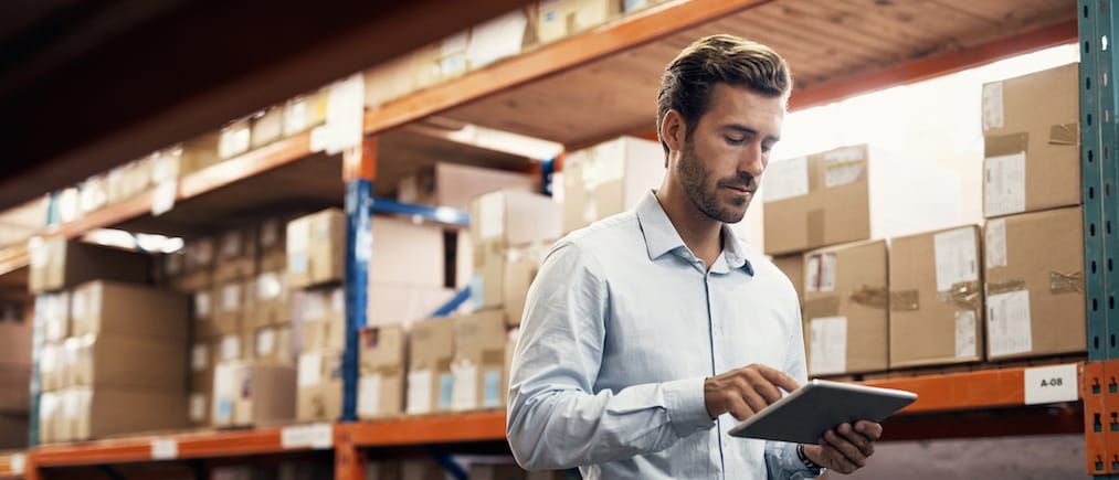 Shot of a young man using a digital tablet while working in a warehouse
